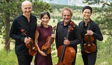 Takacs Quartet stood outside, holding violins and a cello