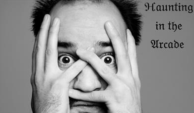 Comedian Daniel Nicholas half covering his eyes
