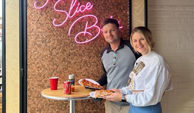 A couple eating pizza at Slice Bros