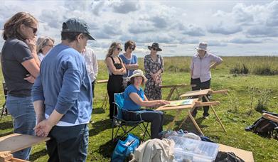 People watching an art demonstration on Cleeve Hill
