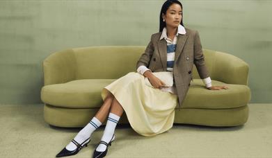 Model sitting on a pistachio coloured sofa