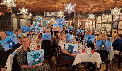 Group of ladies showing their cow paintings